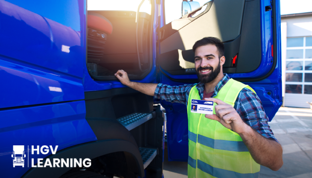 Someone next to an HGV truck holding their HGV provisional licence .